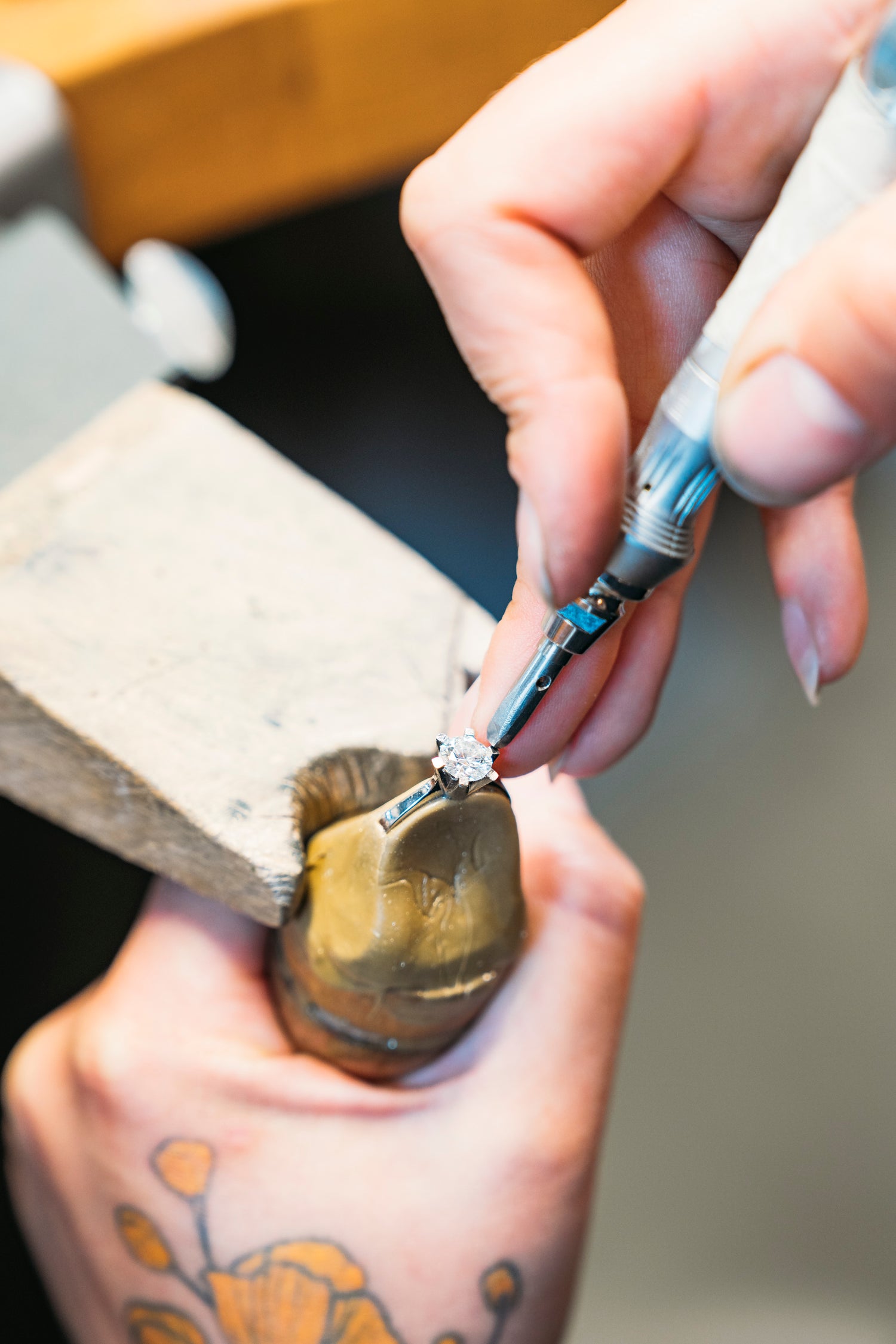Eine EDelsteinfasserin fasst einen Einkaräter in einen Verlobungsring von Jan Spille-Schmuck