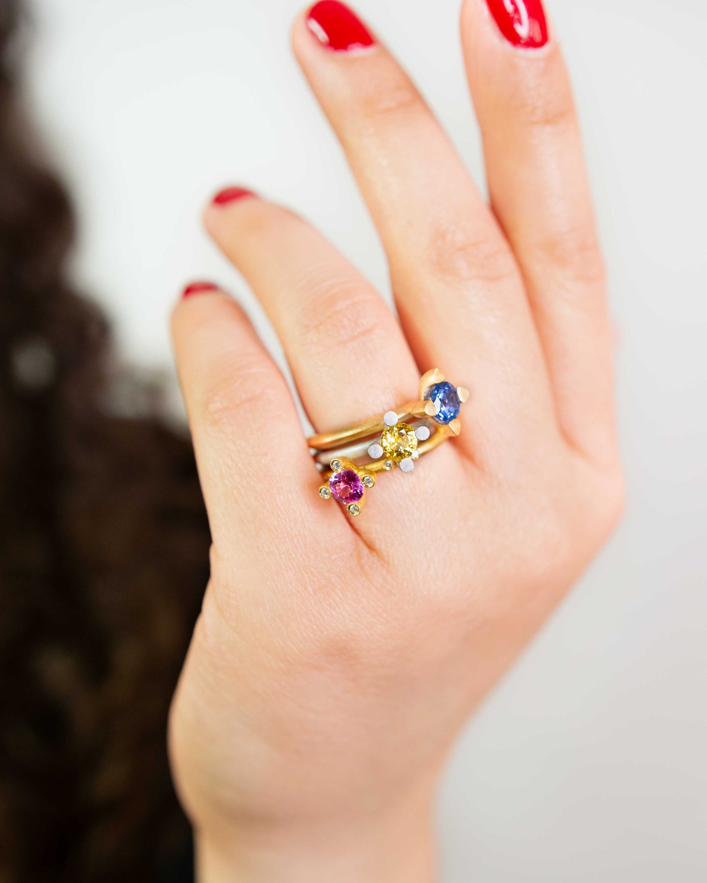 Getragene Kombination mehrerer Ringe mit Saphiren & Diamanten – hochwertiger Goldschmuck aus Hamburg.