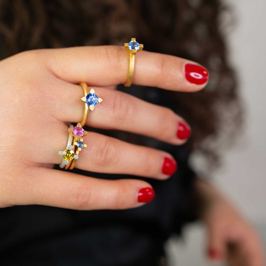 Verschiedene Saphir ringe der Ceylon-Kollektion in Rosé-, Weiß- und Gelbgold – an der Hand getragen, nachhaltig & fair gefertigt.