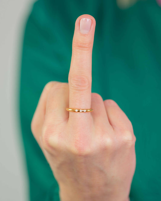 Frau trägt runder diamant ring am Mittelfinger: Gelbgold-Verlobungsring mit funkelndem Diamanten – Fine Jewelry von Jan Spille.