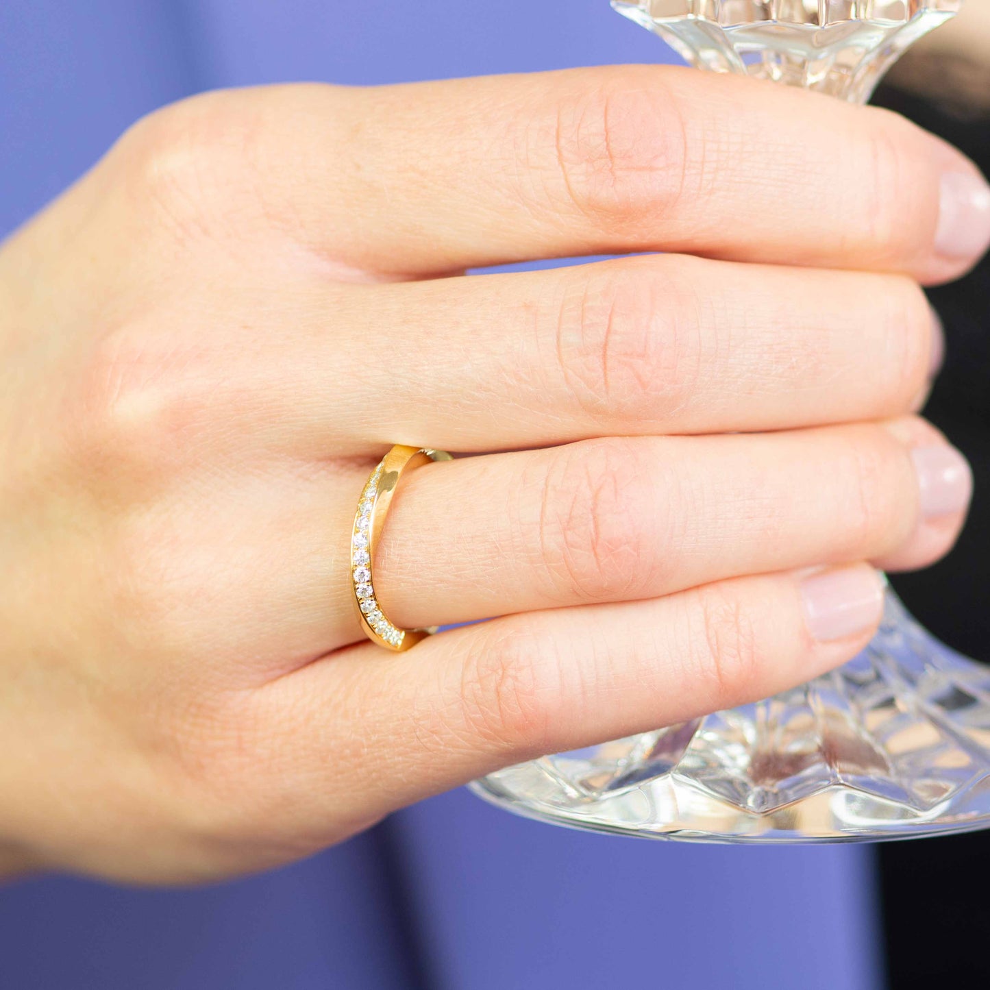 nahaufnahme einer hand zeigt Ring gedreht mit Stein in gelbgold mit fairen diamanten in nachhaltigefr schmuckkollektion von jan spille